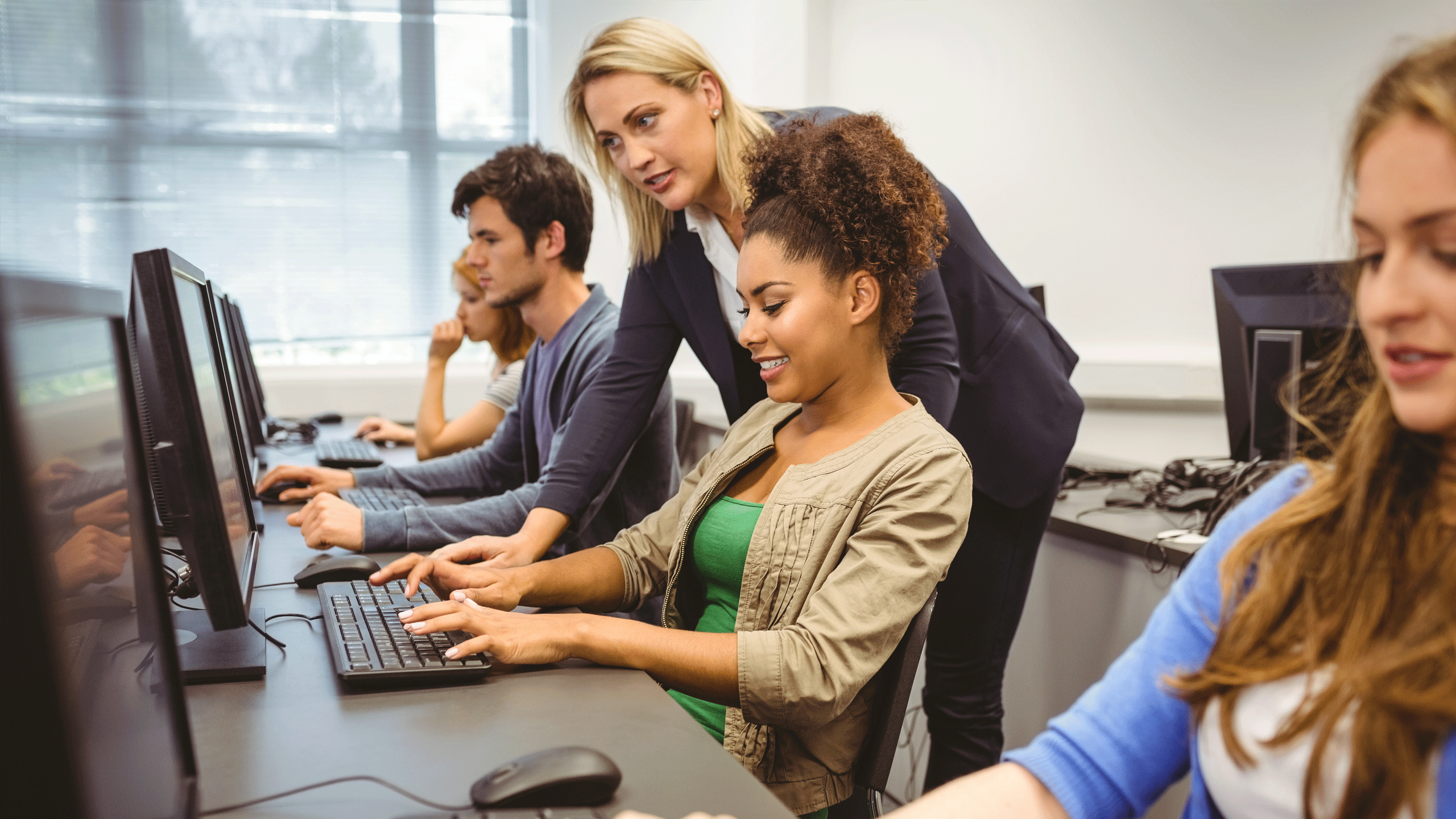 Students in a computer science lesson working from a computer.