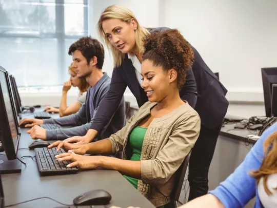 Students in a computer science lesson working from a computer.