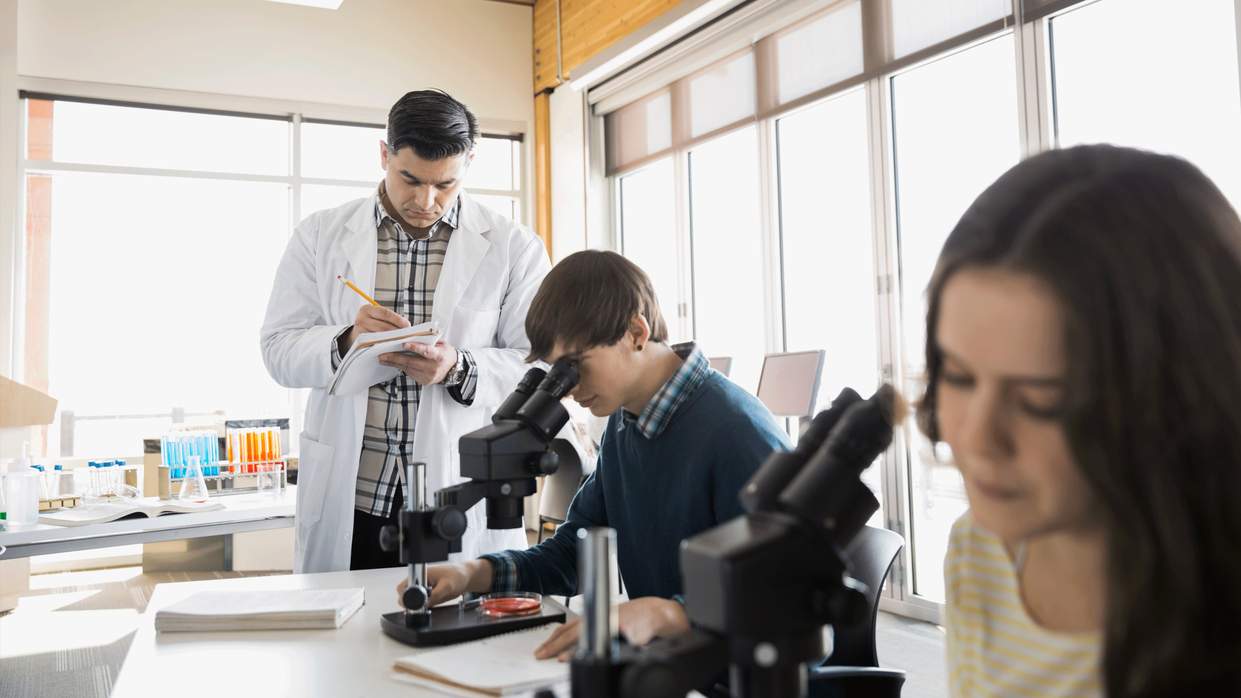 Students looking through a microscope in a science lesson.