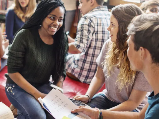Teacher speaking directly with two students.