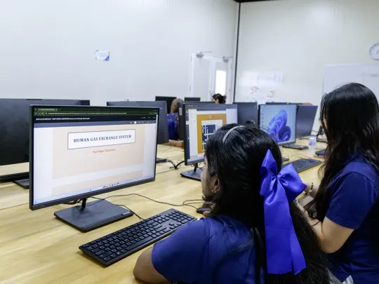 Photo of Windfield International School students studying on a computer.