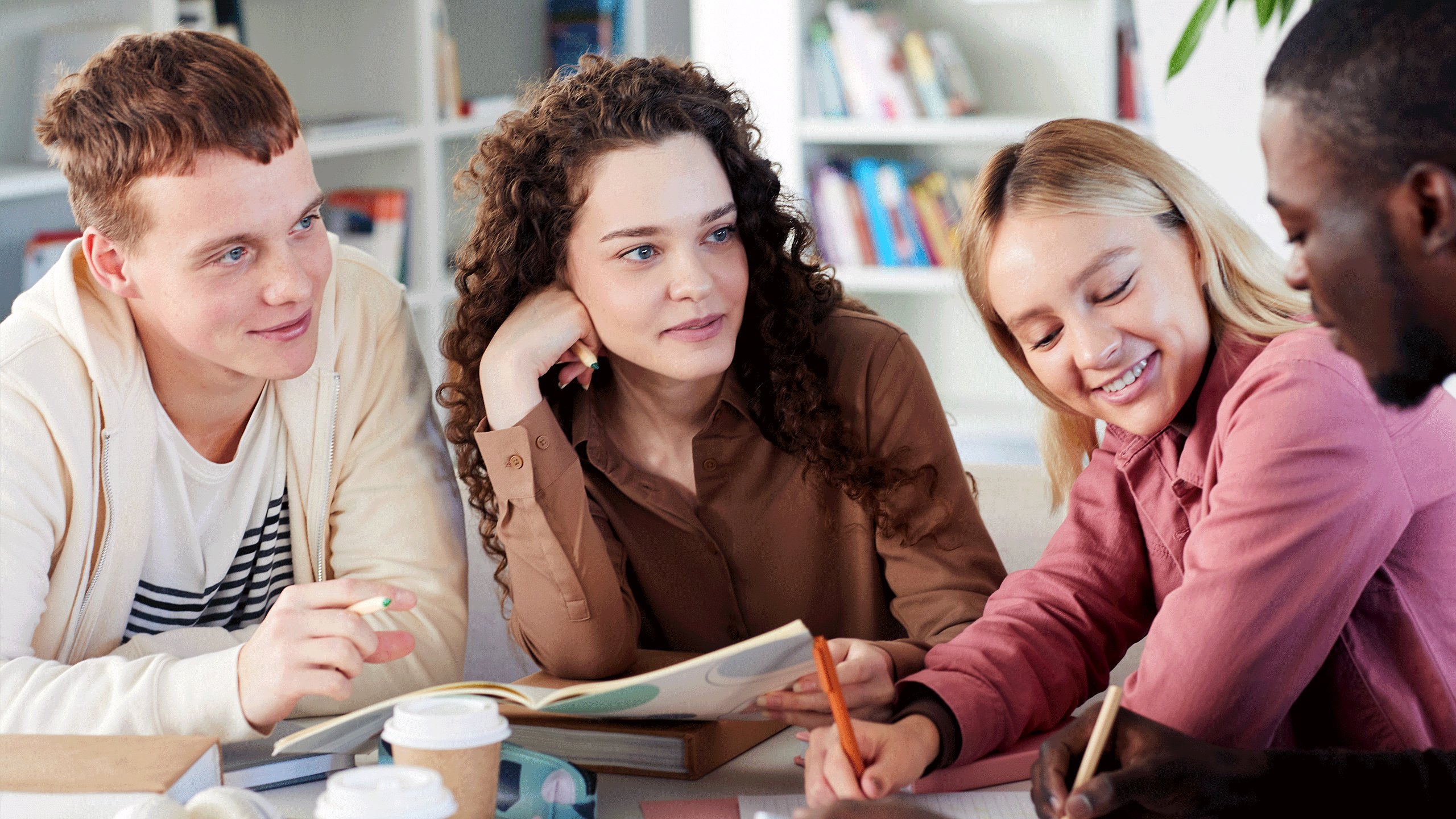 A mixed group of students discussing amongst themselves.