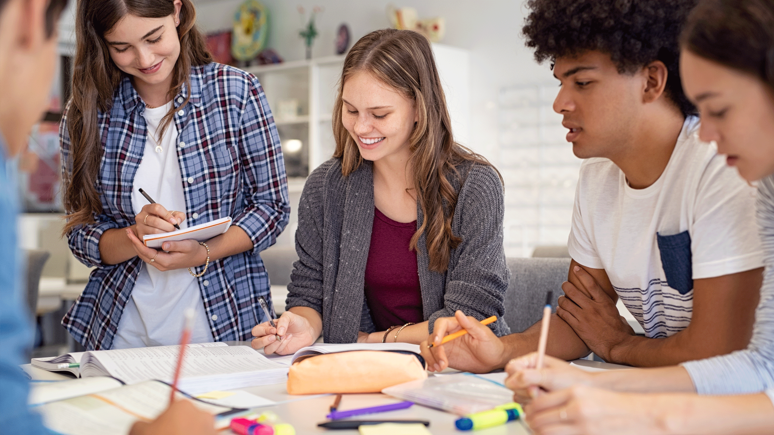 Mixed group of students making notes during a group discussion.