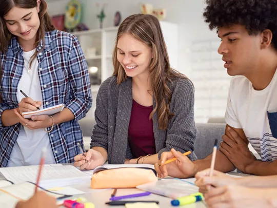 Mixed group of students making notes during a group discussion.